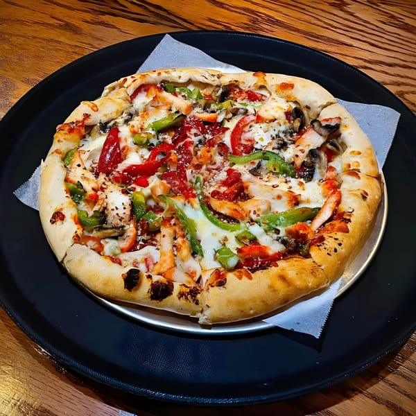 Tikka and Grill's chicken tikka pizza with red and green peppers, mushrooms, and cheese.